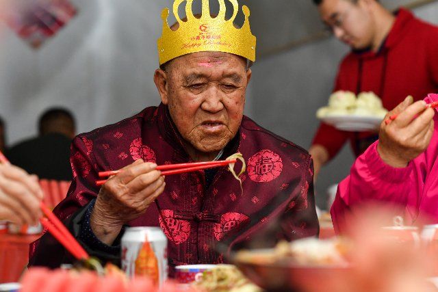 (210427) -- TAIYUAN, April 27, 2021 (Xinhua) -- Hu Zaizhong enjoys food at his birthday banquet at Xuejiawan Village, Liulin County, Lyuliang City of north China\