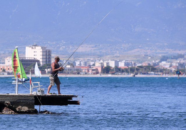(210528) -- CAGLIARI (ITALY), May 28, 2021 (Xinhua) -- A man fishes at the seaside in Cagliari, Sardinia, Italy, on May 28, 2021. All Italian regions have turned to "yellow" since Monday, indicating a low risk of contagion, and the lowest level of anti-COVID-19 restrictions, according to the country\