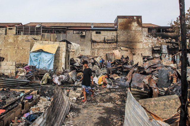 (210520) -- PASIG CITY, May 20, 2021 (Xinhua) -- Residents search for their belongings through their charred homes after a fire at a slum area in Pasig City, the Philippines on May 20, 2021. (Xinhua\/Rouelle Umali