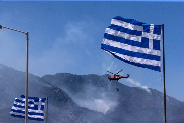(210521) -- ALEPOCHORI, May 21, 2021 (Xinhua) -- A helicopter works to contain a wildfire in Alepochori, Greece, on May 21, 2021. A wildfire that broke out late Wednesday night was still raging in seaside resorts an hour\