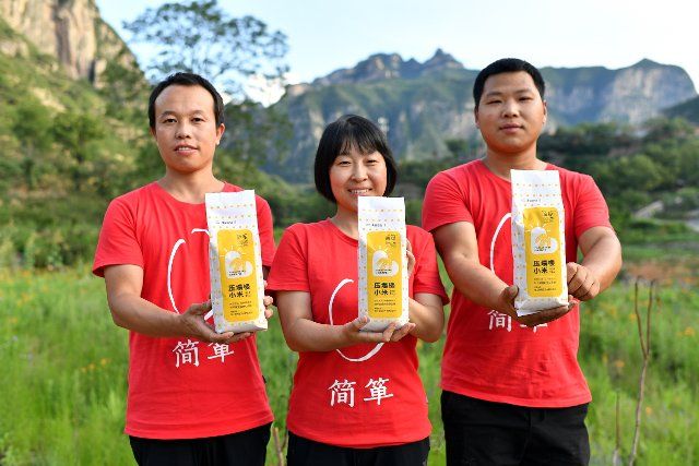 (210710) -- TAIYUAN, July 10, 2021 (Xinhua) -- Wei Meiling (C) shows packed millet products with her colleagues in Langshuyuan Village in Pingshun County, north China\