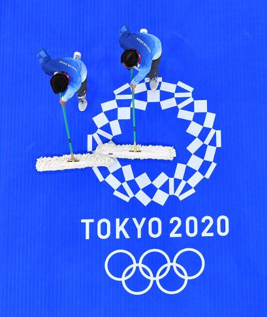 (210724) -- TOKYO, July 24, 2021 (Xinhua) -- Staff members clean the floor after a taekwondo match at the Tokyo 2020 Olympic Games in Tokyo, Japan, July 24, 2021. (Xinhua\/Wang Yuguo