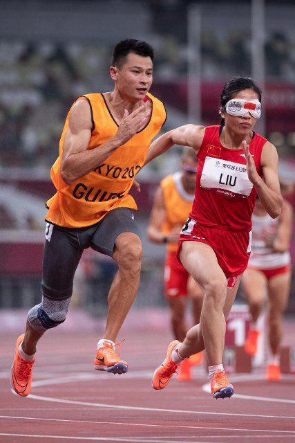 (210827) -- TOKYO, Aug. 27, 2021 (Xinhua) -- Liu Cuiqing (R) of China running with her guide Xu Donglin competes during the women\