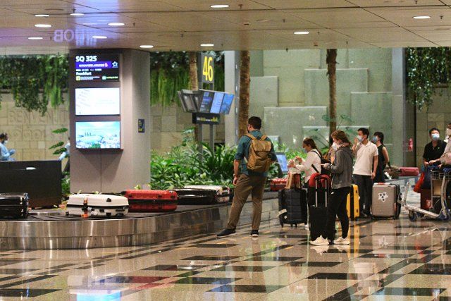 (210909) -- SINGAPORE, Sept. 9, 2021 (Xinhua) -- Travellers on Singapore Airlines flight SQ325 pick up luggage in the baggage hall at Singapore\