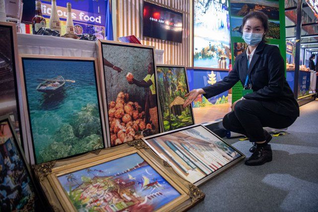 (211116) -- CHONGQING, Nov. 16, 2021 (Xinhua) -- A staff member displays exhibits at an exhibition of the 14th China-LAC Business Summit in southwest China\