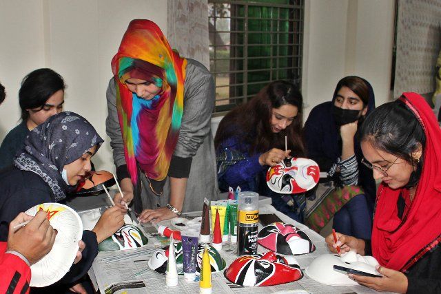 (211217) -- LAHORE, Dec. 17, 2021 (Xinhua) -- People learn Chinese opera face painting art during an event held by the Confucius Institute at the University of Punjab in Lahore, Pakistan, on Dec. 16, 2021. (Photo by Jamil Ahmed\/Xinhua