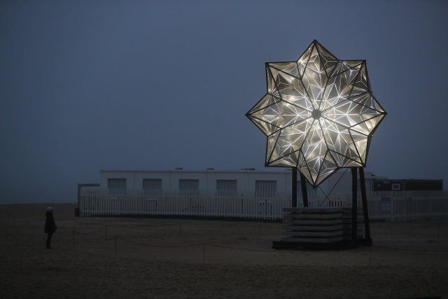 (211218) -- KNOKKE-HEIST (BELGIUM), Dec. 18, 2021 (Xinhua) -- A woman views an installation named "Star in Motion" during a light art festival in Knokke-Heist, Belgium, on Dec. 18, 2021. (Xinhua\/Zheng Huansong