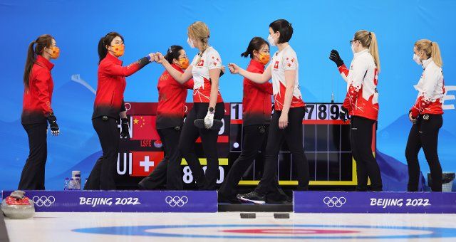 (220210) -- BEIJING, Feb. 10, 2022 (Xinhua) -- Athletes of Switzerland greet to athletes of China before the Curling Women\