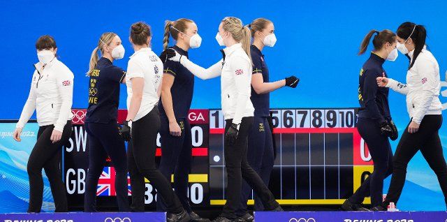 (220210) -- BEIJING, Feb. 10, 2022 (Xinhua) -- Athletes of Britain greets to athletes of Sweden during the Curling Women\