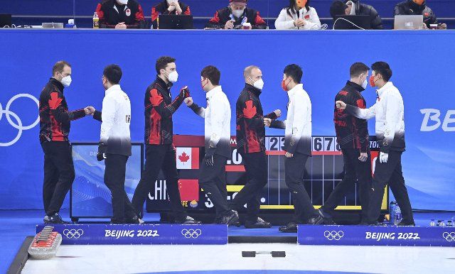 (220215) -- BEIJING, Feb. 15, 2022 (Xinhua) -- Athletes of China and Canada greet each other during the curling men\