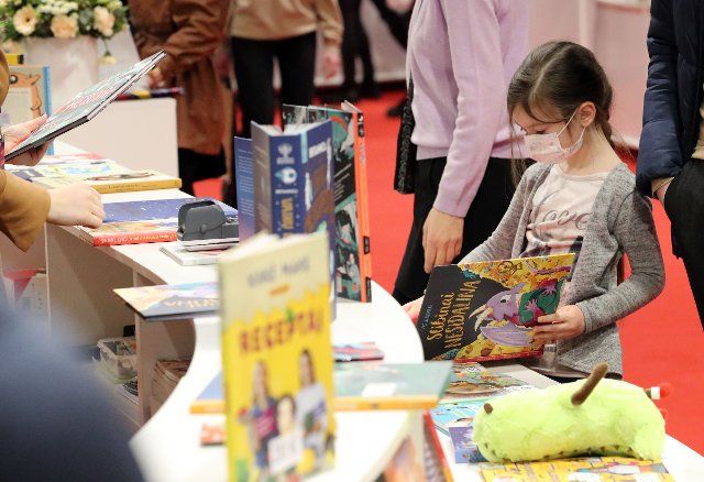 (220225) -- VILNIUS, Feb. 25, 2022 (Xinhua) -- A girl reads a book at the Vilnius Book Fair 2022 in Vilnius, Lithuania, on Feb. 25, 2022. (Xinhua\/Xue Dongmei