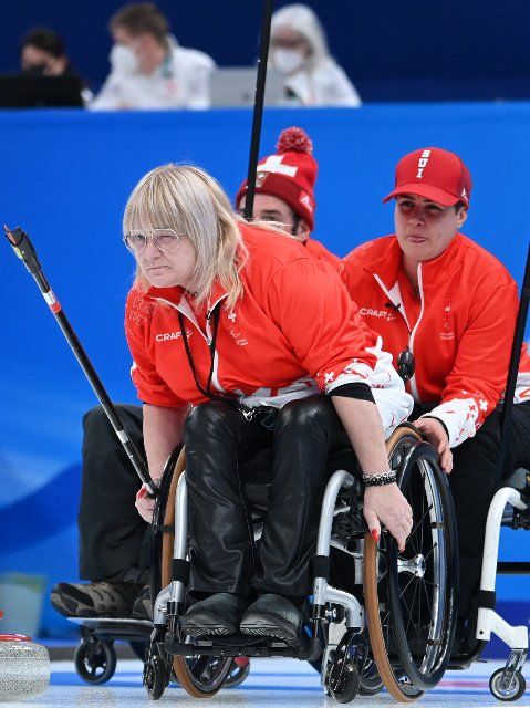 (220305) -- BEIJING, March 5, 2022 (Xinhua) -- Francoise Jaquerod(front) of Switzerland competes during the Wheelchair Curling Round Robin Match between Switzerland and Sweden of Beijing 2022 Paralympic Winter Games at National Aquatics Center in Beijing, capital of China on March 5, 2022. (Xinhua\/Ren Chao