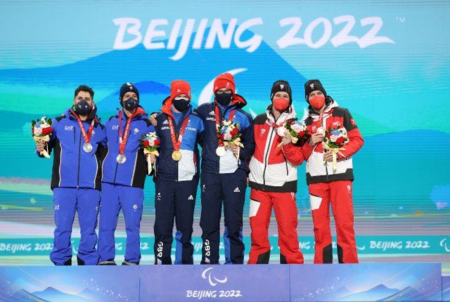 (220306) -- BEIJING, March 6, 2022 (Xinhua) -- Medalists and their guides pose for a group photo during the awarding ceremony for the Alpine Skiing Men\
