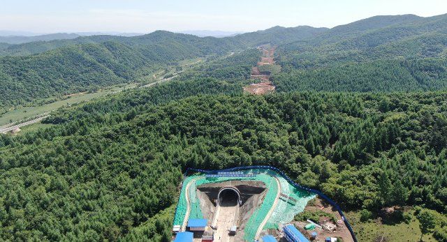 (220625) -- XINBIN, June 25, 2022 (Xinhua) -- Aerial photo taken on June 25, 2022 shows the Yongling No. 2 tunnel of the high-speed railway linking Shenyang with the Changbai Mountains in northeast China. The Yongling No. 2 tunnel on Saturday fully completed its construction. It is the first tunnel that saw construction completed along the under-construction Shenyang-Changbai Mountain high-speed railway. The 430.1-km-long Shenyang-Changbai Mountain railroad kicked off its construction in July 2021 with a designed speed of 350 km per hour. (Xinhua\/Yang Qing