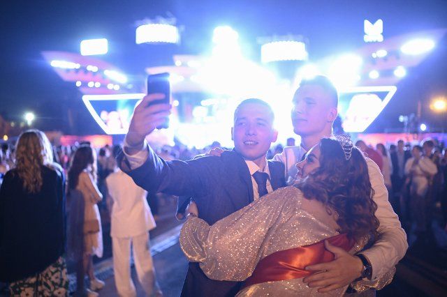 (220626) -- MOSCOW, June 26, 2022 (Xinhua) -- Graduates take selfies during a graduation party in Moscow, Russia, on June 26, 2022. The graduation party for high school students was held from the night of June 25 to the morning of June 26 at Gorky Park in Moscow. (Photo by Alexander Zemlianichenko Jr\/Xinhua