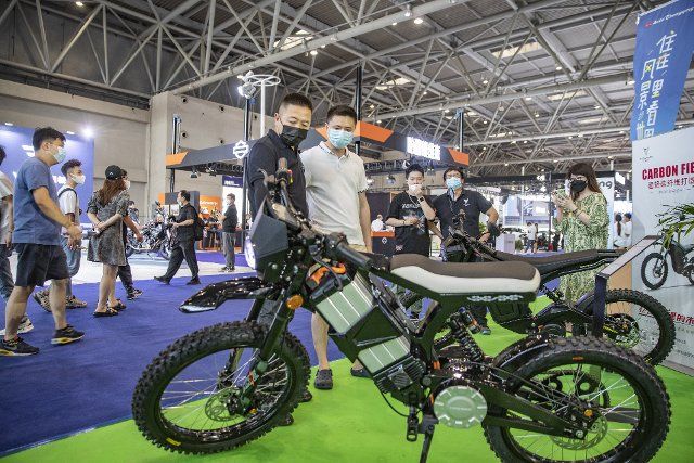 (220626) -- CHONGQING, June 26, 2022 (Xinhua) -- A staff member introduces an electric off-road motorcycle made of ultra-light carbon fiber materials during the 2022 Chongqing International Auto Exhibition in southwest China\