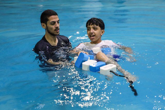 (220626) -- GAZA, June 26, 2022 (Xinhua) -- A Palestinian specialist conducts autism aquatic therapy for a child in a pool at Dolfin Club and Resort in Gaza City, June 26, 2022. (Photo by Rizek Abdeljawad\/Xinhua