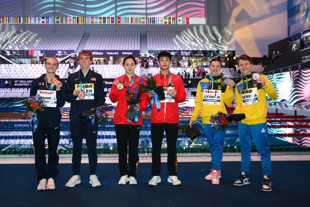 (220702) -- BUDAPEST, July 2, 2022 (Xinhua) -- Gold medalists Ren Qian (3rd L)\/Duan Yu (3rd R) of China, silver medalists Sofiia Lyskun (2nd R)\/Oleksii Sereda (1st R) of Ukraine, bronze medalists Delaney Schnell (1st L)\/Carson Tyler (2nd L) of the United States pose after the mixed 10m synchronised final of diving at the 19th FINA World Championships in Budapest, Hungary, July 1, 2022. (Xinhua\/Zheng Huansong
