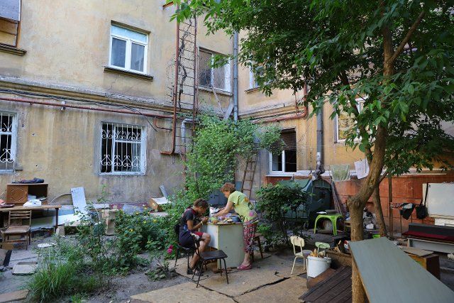 (220619) -- MARIUPOL, June 19, 2022 (Xinhua) -- Residents have meal outside their apartment building in Mariupol June 18, 2022. (Photo by Victor\/Xinhua