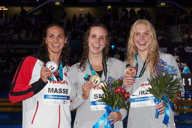 (220621) -- BUDAPEST, June 21, 2022 (Xinhua) -- Silver medalist Kylie Masse (L) of Canada, gold medalist Regan Smith (C) of the United States and bronze medalist Claire Curzan of the United States pose for photos during the awarding ceremony after after the women\