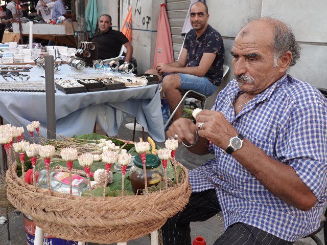 (220808) -- TUNIS, Aug. 8, 2022 (Xinhua) -- A jasmine seller makes "Machmoum," a little bouquet made of jasmine, in Tunis, Tunisia, Aug. 6, 2022. TO GO WITH "Feature: Tunisian jasmine sellers struggle to make ends meet amid global business decline" (Xinhua\/Xu Supei