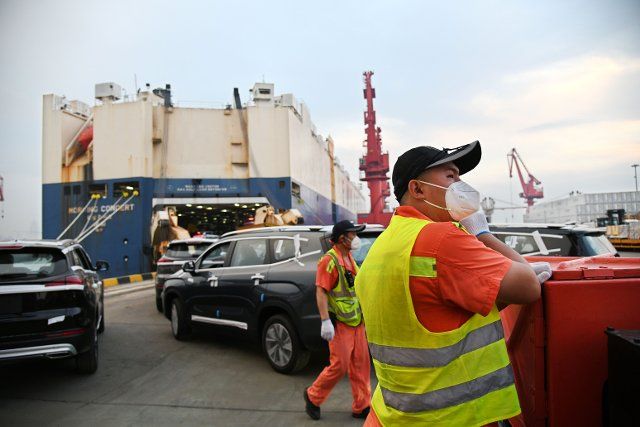 (220808) -- QINGDAO, Aug. 8, 2022 (Xinhua) -- Staff work during the shipment of commercial vehicles onto a ro-ro cargo vessel to depart for Africa at Qingdao Port in Qingdao, east China\