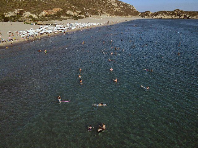 (220810) -- ANKARA, Aug. 10, 2022 (Xinhua) -- Tourists play on the beach in Antalya, T¨¹rkiye, on Aug. 9, 2022. T¨¹rkiye\