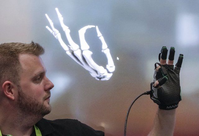 (220810) -- VANCOUVER, Aug. 10, 2022 (Xinhua) -- An exhibitor demonstrates a glove with motion capture technology during the SIGGRAPH 2022 in Vancouver, British Columbia, Canada, on Aug. 9, 2022. The SIGGRAPH is a premier conference and exhibition on computer graphics and interactive techniques. (Photo by Liang Sen\/Xinhua