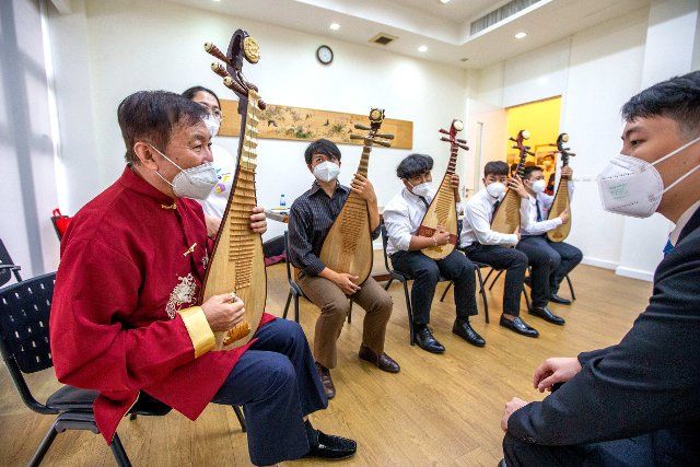 (220810) -- BANGKOK, Aug. 10, 2022 (Xinhua) -- People learn to play pipa, a four-stringed Chinese lute, at China Culture Center in Bangkok, Thailand, Aug. 9, 2022. Students of Kanlayanee school watched a documentary about Sanxingdui, and experienced traditional Chinese cultural activities at China Culture Center in Bangkok. (Xinhua\/Wang Teng