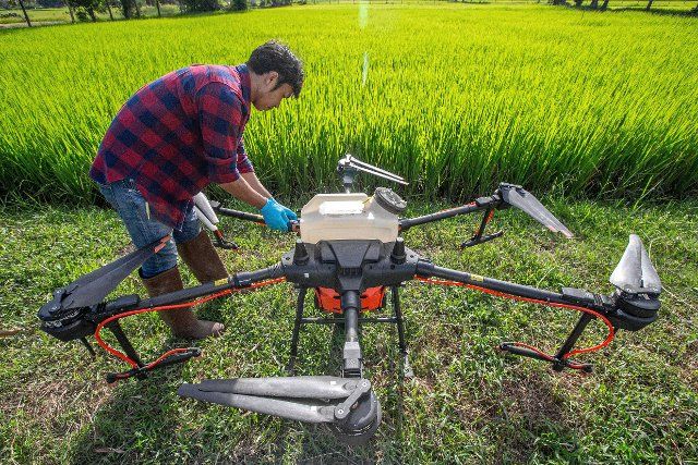 (220811) -- ROI ET, Aug. 11, 2022 (Xinhua) -- A Thai farmer checks a DJI agricultural drone in Roi Et, Thailand, on Aug. 1, 2022. China-made agricultural drones are seen flying over grainfields in this southeast Asian country to help local farmers produce more efficiently, conveniently, and safely. (Xinhua\/Wang Teng