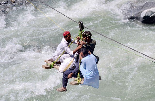 (220905) -- SWAT, Sept. 5, 2022 (Xinhua) -- Local residents use a temporary cradle service to cross the river Swat after flash floods in Bahrain area of northwest Pakistan\