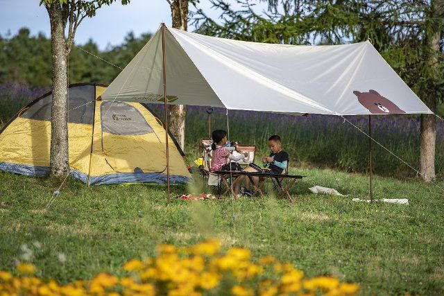 (220811) -- CHONGQING, Aug. 11, 2022 (Xinhua) -- Tourists go camping in Hongchiba scenic area in Wuxi County of southwest China\