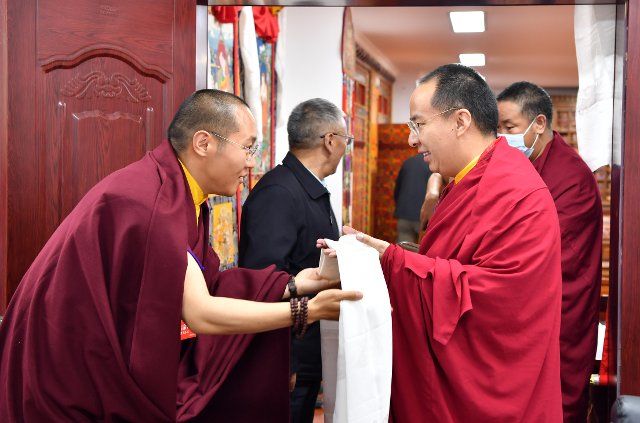 (220811) -- LHASA, Aug. 11, 2022 (Xinhua) -- A Buddhist monk presents a hada, a silk scarf used to express respect and greeting, to Panchen Erdeni Chos-kyi rGyal-po on June 2, 2022. Panchen Erdeni Chos-kyi rGyal-po had performed his daily duties as president of the Tibet branch of the Buddhist Association of China in Lhasa since mid-May. (Xinhua\/Chogo