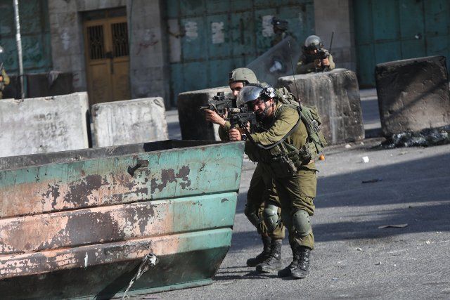 (220812) -- HEBRON, Aug. 12, 2022 (Xinhua) -- Israeli soldiers aim their weapons at Palestinian protesters during clashes following a protest against the expansion of Jewish settlements, in the West Bank city of Hebron, Aug. 12, 2022. (Photo by Mamoun Wazwaz\/Xinhua