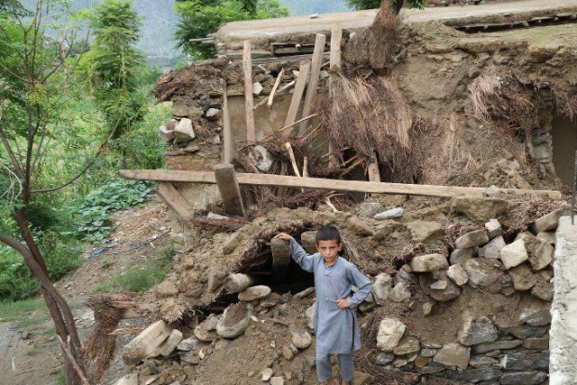 (220818) -- NURISTAN, Aug. 18, 2022 (Xinhua) -- A boy stands in front of the rubbles of houses destroyed by flood in Nuristan province, Afghanistan, Aug. 18, 2022. Heavy rain and flash flood have killed 15 people in Afghanistan\
