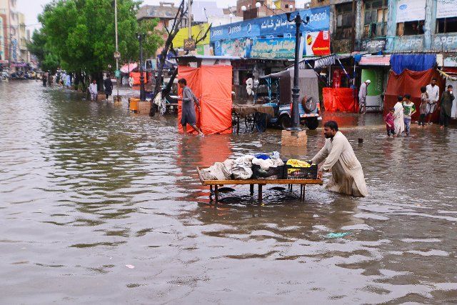 (220818) -- HYDERABAD (PAKISTAN), Aug. 18, 2022 (Xinhua) -- A vendor pushes a cart in the flooded water in Hyderabad, Pakistan, on Aug. 18, 2022. At least 14 people were killed and 14 others injured in heavy monsoon rain-triggered flash floods and other rain-related incidents during the last 24 hours in Pakistan, the National Disaster Management Authority (NDMA) said Wednesday evening. (Str\/Xinhua