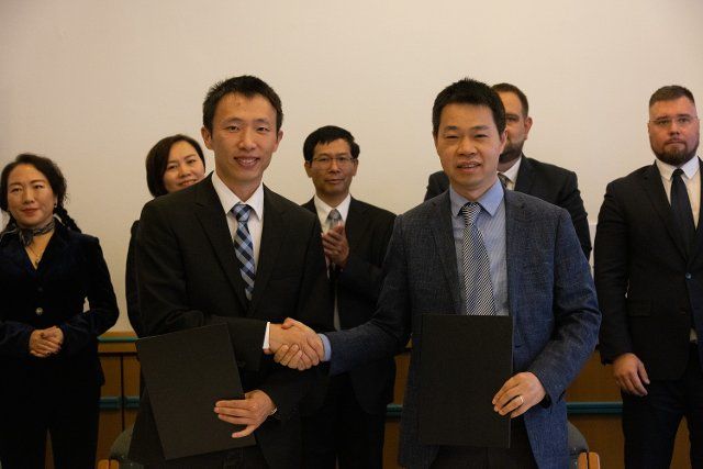 (221005) -- BUDAPEST, Oct. 5, 2022 (Xinhua) -- Wei Zifeng (L, Front), vice president of Intretech Hungary, shakes hands with Kong Jian (R, Front), founder of Shanghai Kuaibu New Energy Technology (KBVIP), after signing an agreement in Budapest, Hungary, on Oct. 5, 2022. Shanghai Kuaibu New Energy Technology (KBVIP) of China signed its first photovoltaic (PV), battery storage and electric vehicle (EV) charging pilot project agreement with Intretech here on Wednesday. (Photo by Attila Volgyi\/Xinhua
