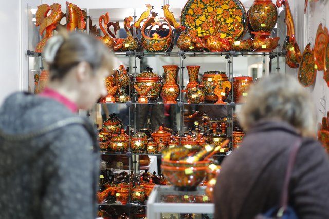 (221007) -- MOSCOW, Oct. 7, 2022 (Xinhua) -- Visitors look at painted wooden goods during the "Firebird" exhibition and fair, an annual event for folk craftsmen and artisans from Russia, in Moscow, Russia, Oct. 6, 2022. (Photo by Alexander Zemlianichenko Jr\/Xinhua