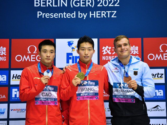 (221022) -- BERLIN, Oct. 22, 2022 (Xinhua) -- Gold medalist Wang Zongyuan (C) of China, silver medalist Cao Yuan (L) of China and bronze medalist Moritz Wesemann of Germany pose for photos during the awarding ceremony of men\