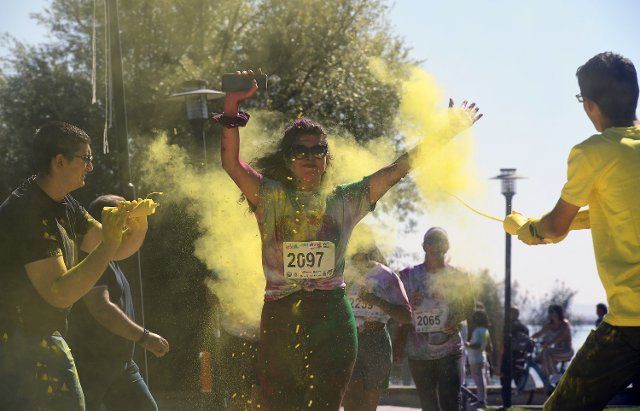 (220926) -- ANKARA, Sept. 26, 2022 (Xinhua) -- A girl is sprayed with colored powder at the "Color Sky 5K" running festival in Ankara, T¨¹rkiye, on Sept. 25, 2022. (Photo by Mustafa Kaya\/Xinhua