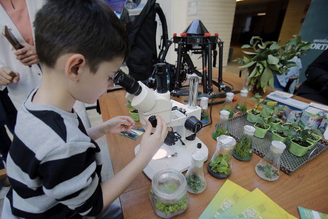 (220926) -- BUCHAREST, Sept. 26, 2022 (Xinhua) -- A child observes plant seeds through a microscope during the Science & Imagination Caravan event at Romania\