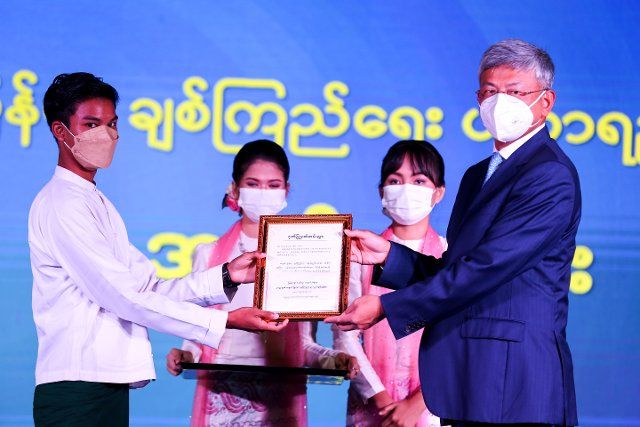 (220926) -- YANGON, Sept. 26, 2022 (Xinhua) -- Chinese Ambassador to Myanmar Chen Hai (1st R) gives the certificate to a student during the awarding ceremony of the China-Myanmar friendship awards in Yangon, Myanmar, Sept. 26, 2022. TO GO WITH "55 outstanding Myanmar students receive China-Myanmar friendship awards" (Photo by Myo Kyaw Soe\/Xinhua