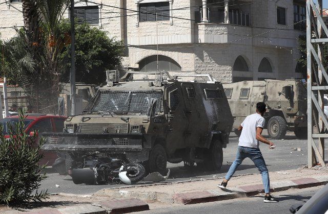 (220928) -- JENIN, Sept. 28, 2022 (Xinhua) -- A protester hurls a stone at Israeli soldiers in the West Bank city of Jenin, Sept. 28, 2022. Three Palestinians were killed and 10 others injured on Wednesday during clashes with Israeli soldiers in the northern West Bank city of Jenin, Palestinian medics and eyewitnesses have said. (Photo by Ayman Nobani\/Xinhua