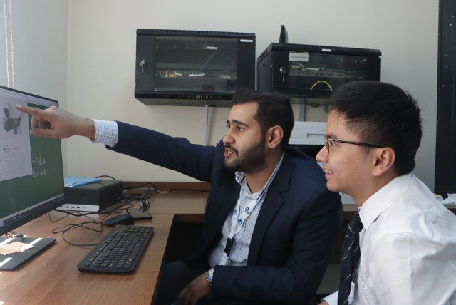 (220930) -- AMMAN, Sept. 30, 2022 (Xinhua) -- Jiang Songwei (R), project engineer of China Three Gorges International Corporation (CTGI) Jordan, communicates with his colleague Nezar Alkhoshaman, the site engineer for the operation and maintenance of the Shobak wind power project, at the Shobak wind farm in Jordan, Sept. 19, 2022. TO GO WITH "Feature: Chinese enterprise helps renewable energy transition in Jordan" (Xinhua\/Ji Ze