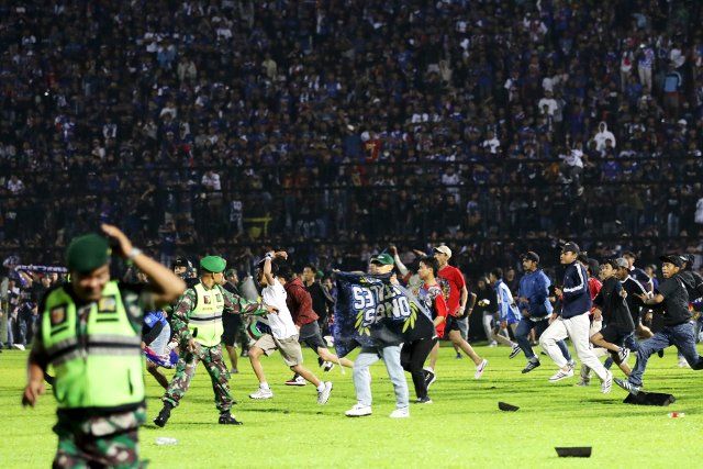 (221002) -- MALANG, Oct. 2, 2022 (Xinhua) -- People enter the football pitch at the Kanjuruhan Stadium in Malang of East Java province, Indonesia, Oct. 1, 2022. The death toll in a crowd stampede at a football match in Indonesia\