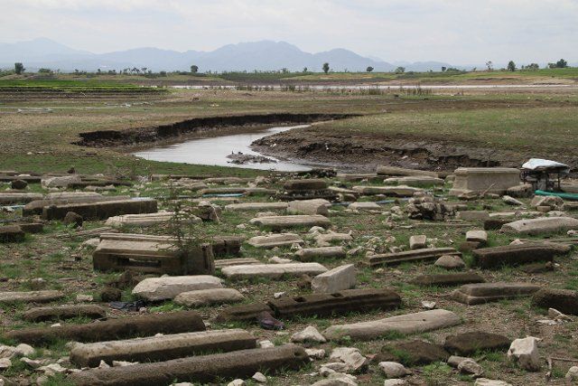 (221004) -- WONOGIRI, Oct. 4, 2022 (Xinhua) -- Photo taken on Oct. 4, 2022 shows graveyards in Gajah Mungkur dam at Wuryantoro district in Wonogiri, Central Java, Indonesia. During the dry season, the water level of the dam subsides, making graveyards visible in the former location of Keteng village in Wuryantoro district. (Photo by Bram Selo\/Xinhua