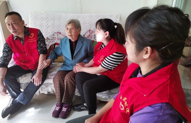 (221005) -- TAIYUAN, Oct. 5, 2022 (Xinhua) -- Photo taken with a mobile phone shows volunteers paying a visit to a senior resident in Chaoyang residential area in Jiancaoping District of Taiyuan, capital of north China\