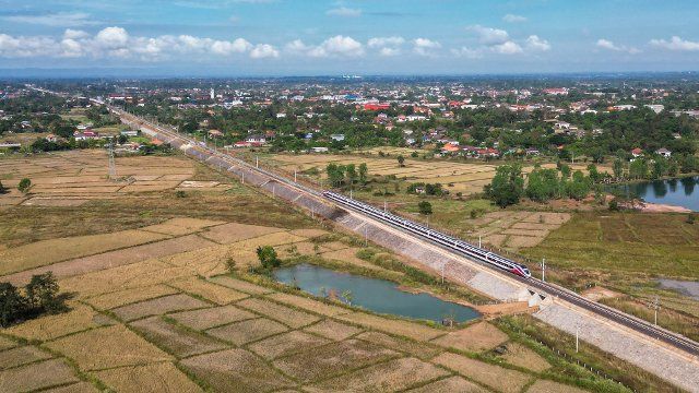 (221129) -- VIENTIANE, Nov. 29, 2022 (Xinhua) -- This aerial photo taken on Nov. 25, 2022 shows a Lane Xang EMU (electric multiple unit) train running on the China-Laos Railway in the suburb of Vientiane, Laos. TO GO WITH "Feature: China-Laos Railway boosts travel, promotes tourism in Laos" (Photo by Kaikeo Saiyasane\/Xinhua