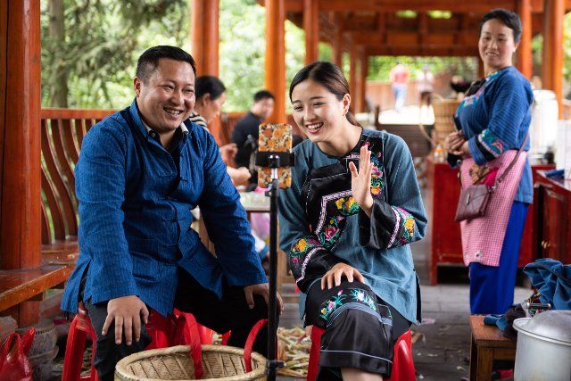 (221129) -- BEIJING, Nov. 29, 2022 (Xinhua) -- Ma Huihuang (L), then head of the poverty alleviation work team in Shibadong, promotes local products via live-streaming together with villager Shi Linjiao in Shibadong Village of Xiangxi Tujia and Miao Autonomous Prefecture, central China\