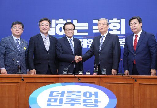 Ruling, opposition leaders Lee Hae-chan (3rd from L), leader of the ruling Democratic Party, and Kim Chong-in, the interim leader of the main opposition United Future Party, shake hands with each other during the latter\